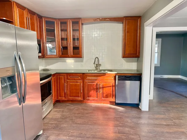 a kitchen with stainless steel appliances granite countertop a stove a sink and a refrigerator