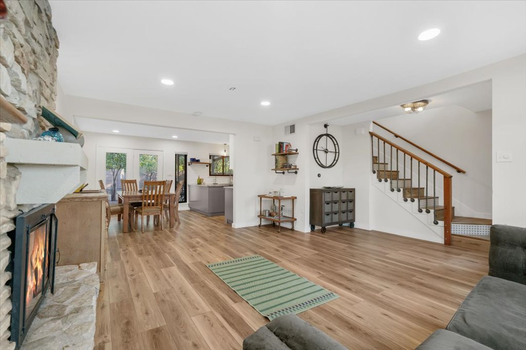 13126 Travis View Loop Austin, TX 78732 - Photo 5 of 27 Eating area view from Living area featuring light wood finished floors, a fireplace, stairway, and recessed lighting