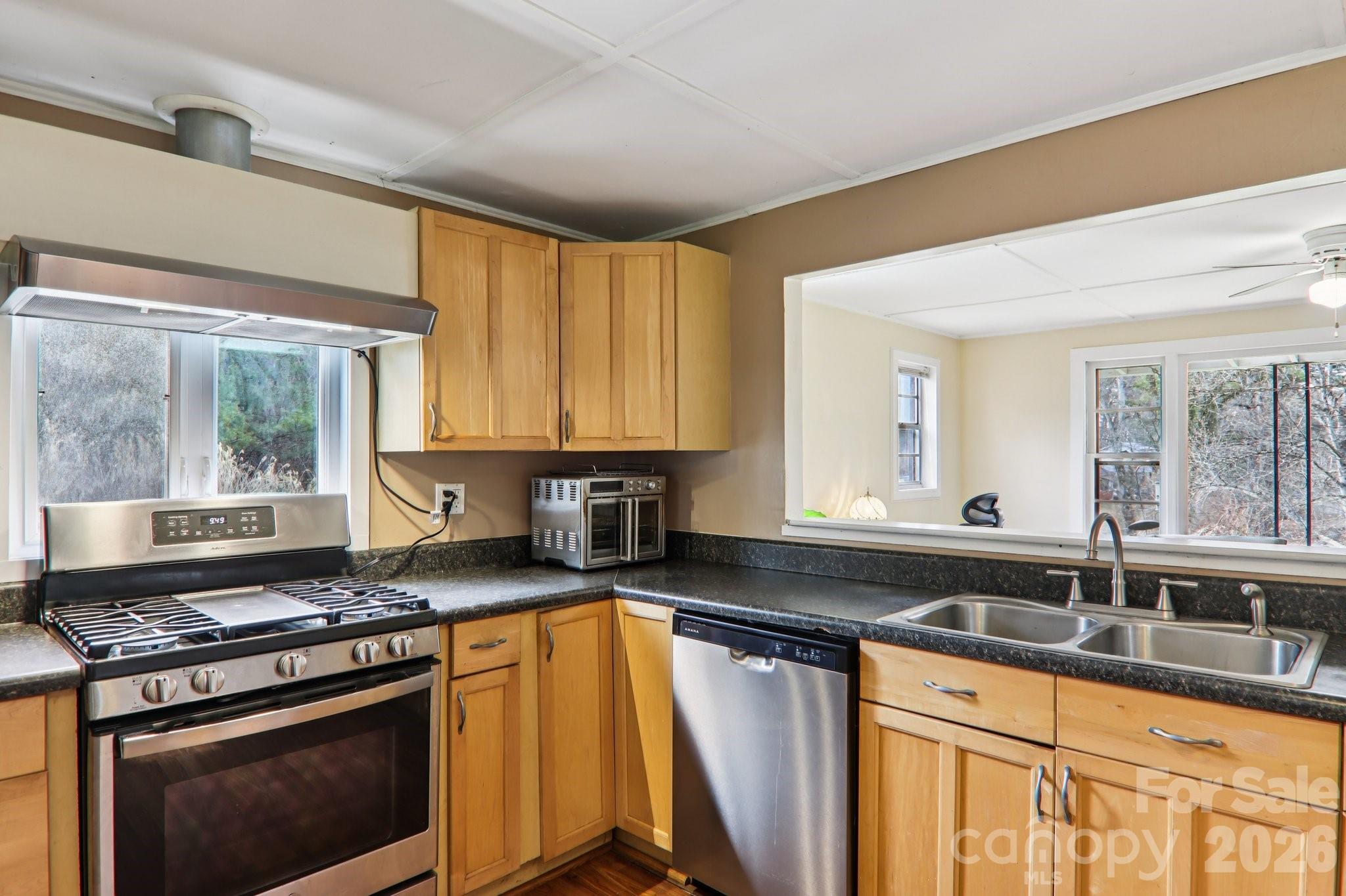 105 Baird Road Mars Hill, NC 28754 - Photo 24 of 48 a kitchen with granite countertop a sink a stove cabinets and stainless steel appliances