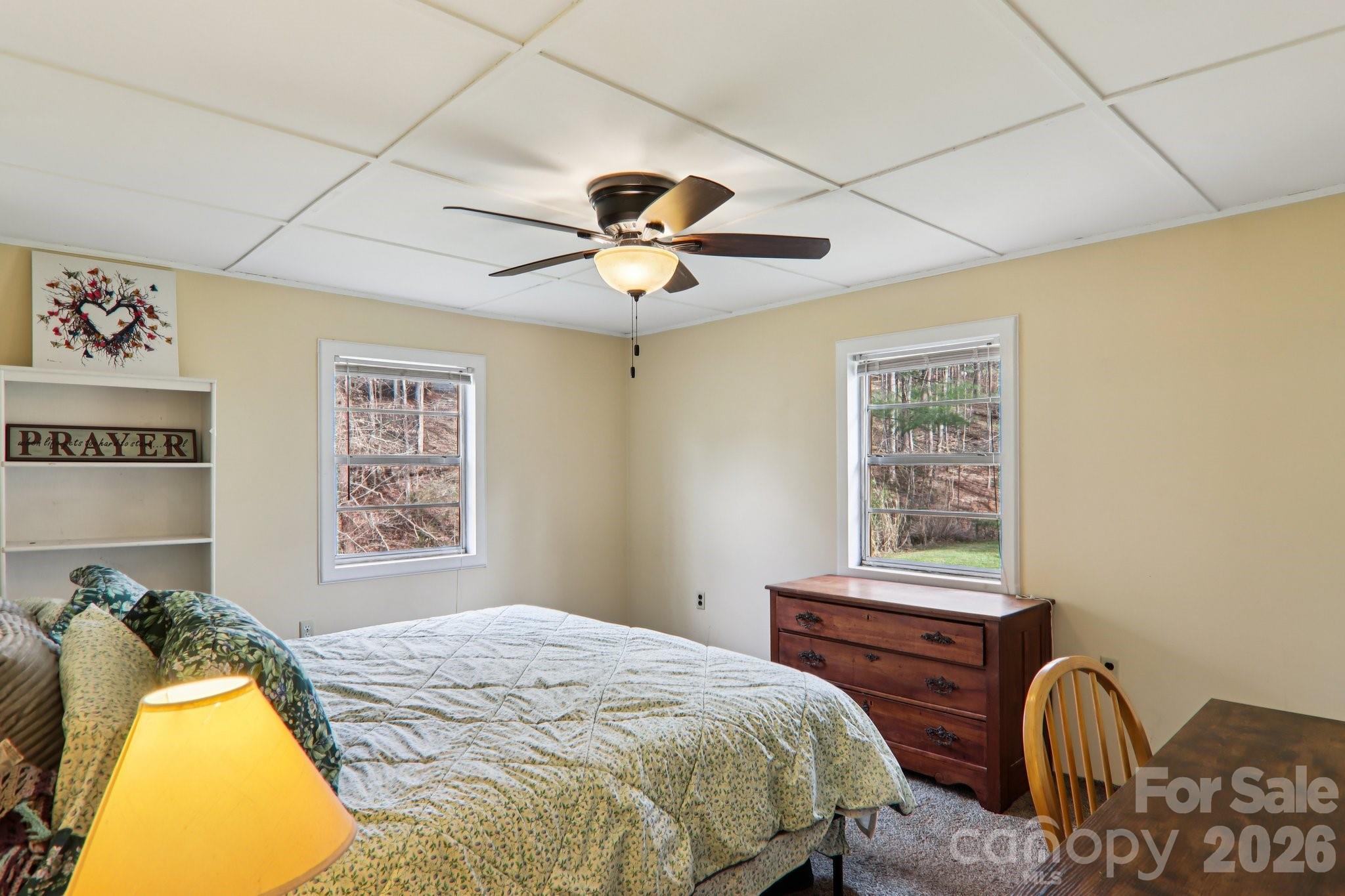 105 Baird Road Mars Hill, NC 28754 - Photo 33 of 48 a bedroom with a bed and a chandelier