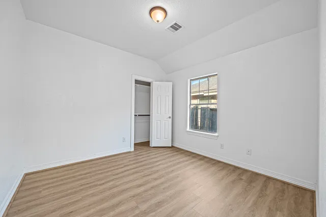 a view of an empty room with wooden floor