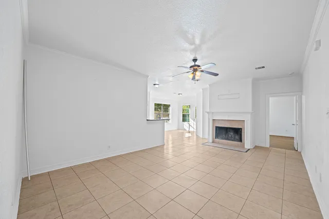 a view of a livingroom with a fireplace a chandelier and windows