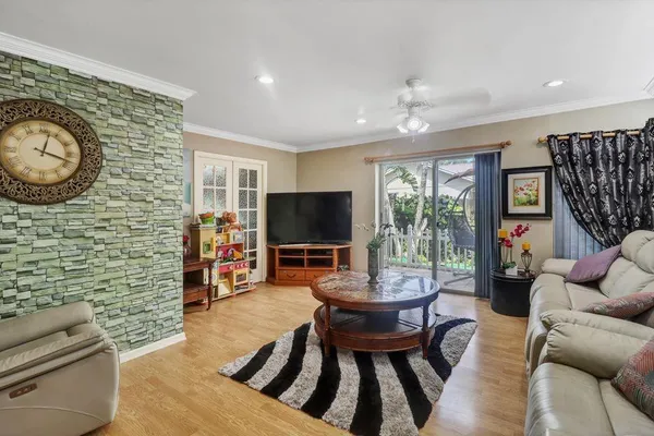 a living room with furniture a flat screen tv and a large window