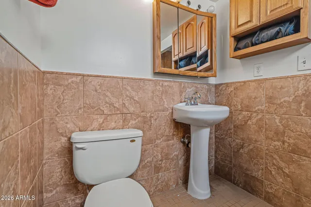 a bathroom with a toilet sink and mirror