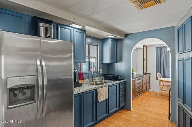 a kitchen with stainless steel appliances granite countertop a refrigerator a stove and a sink