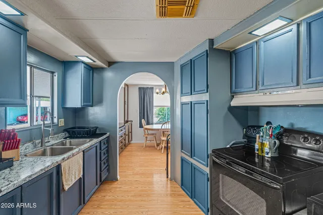 a kitchen with granite countertop a sink stainless steel appliances wooden cabinets and counter space