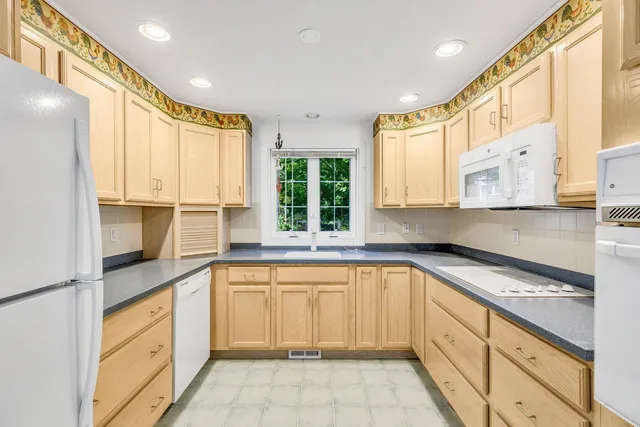 a kitchen with a sink window and cabinets