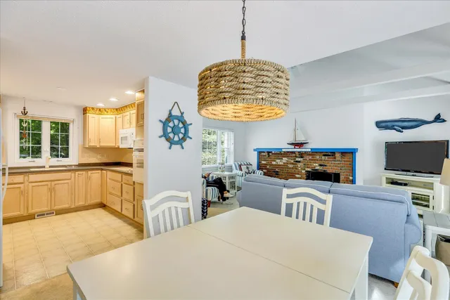 a kitchen with stainless steel appliances kitchen island granite countertop a refrigerator a stove a sink dishwasher and white cabinets with wooden floor