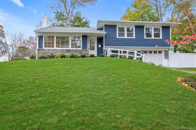a view of a house with a yard potted plants and a table