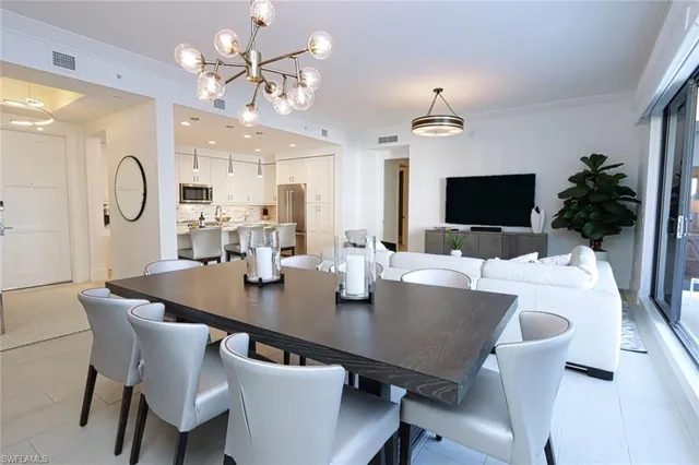 a view of a dining room with furniture and a chandelier fan