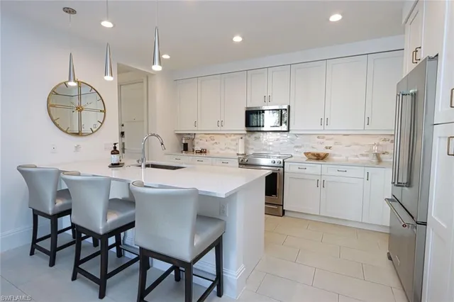a kitchen with a sink white cabinets and stainless steel appliances