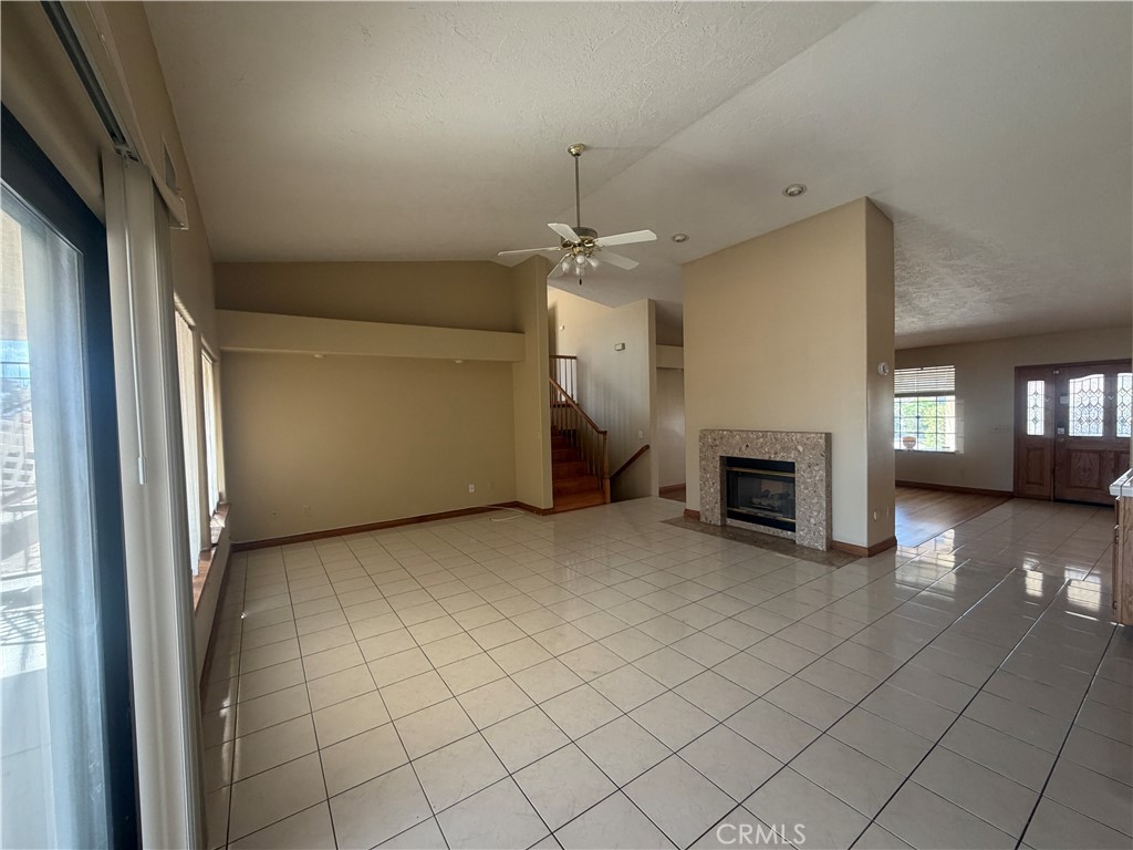 19609 Seneca Road Apple Valley, CA 92307 - Photo 14 of 37 an empty room with fireplace and windows