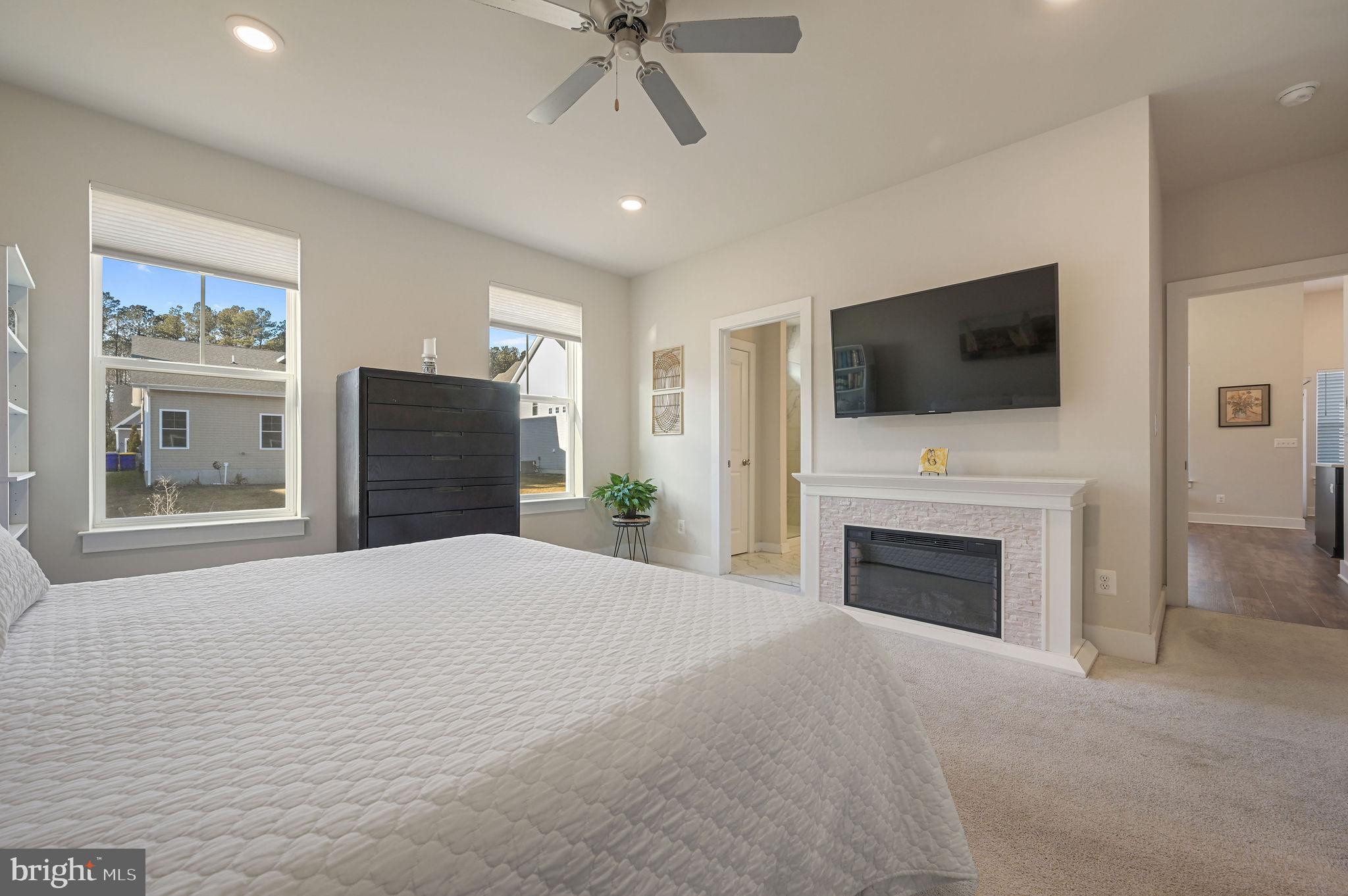 18556 Emerson Way Georgetown, DE 19947 - Photo 17 of 30 a bedroom with furniture fireplace and a flat screen tv