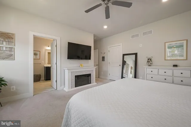 a spacious bedroom with a bed and a flat screen tv