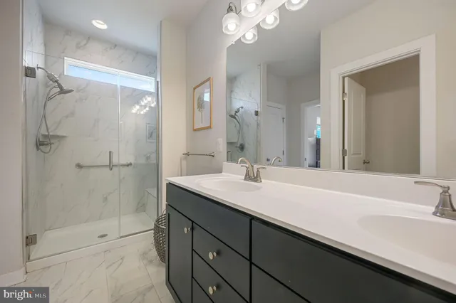 a bathroom with a sink a shower and a mirror