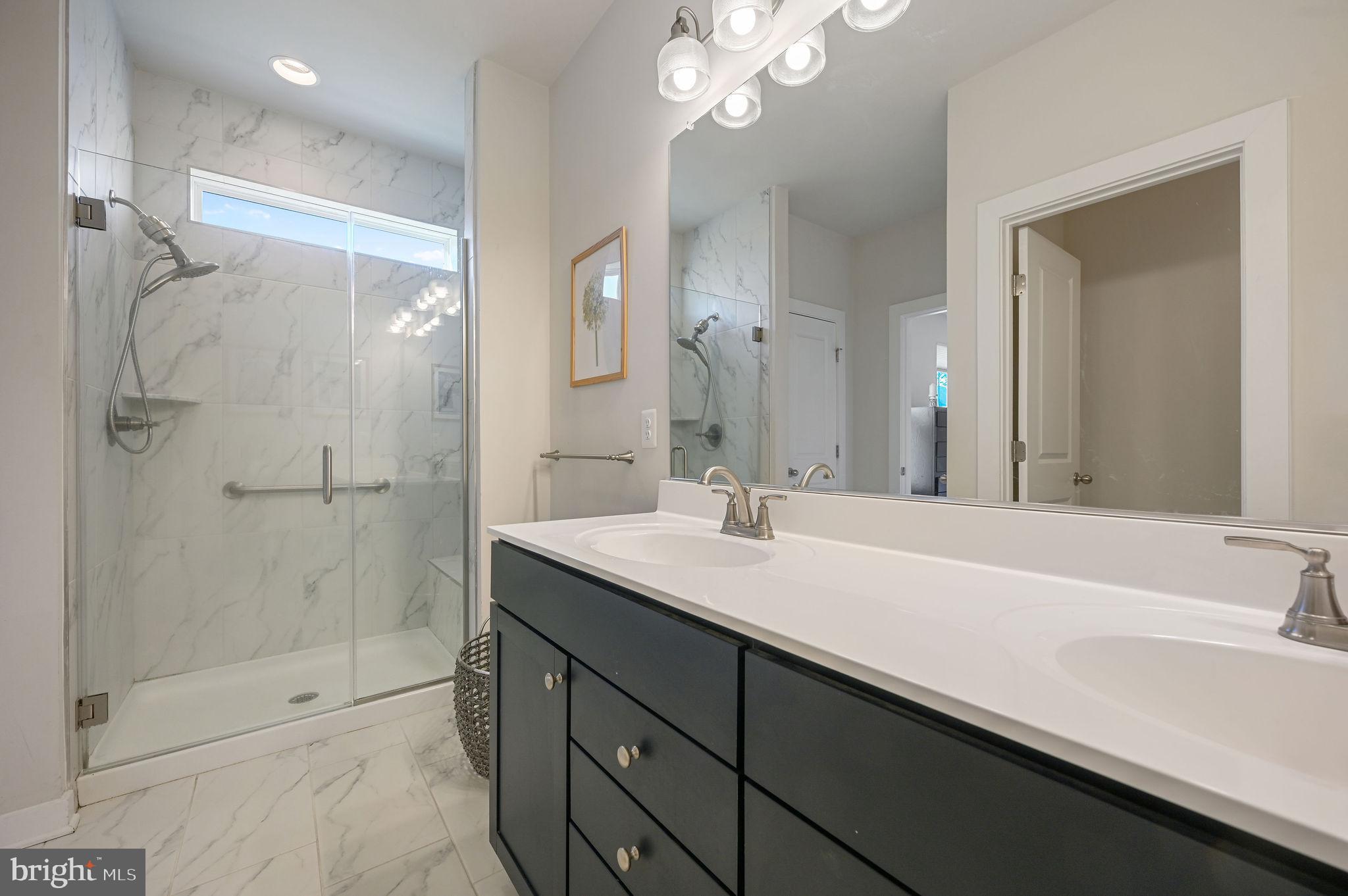 18556 Emerson Way Georgetown, DE 19947 - Photo 19 of 30 a bathroom with a sink a shower and a mirror
