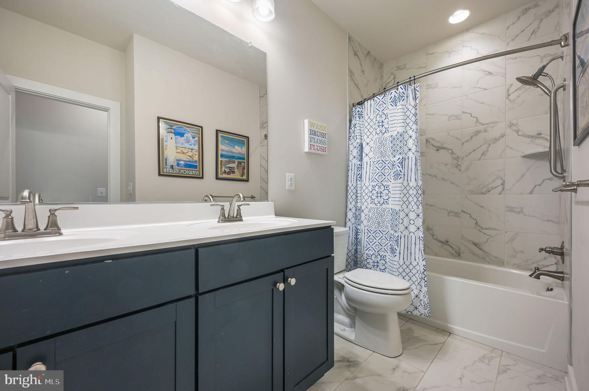 18556 Emerson Way Georgetown, DE 19947 - Photo 22 of 30 a bathroom with a double vanity sink toilet and shower