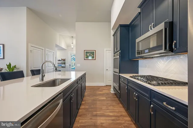 a kitchen with granite countertop stainless steel appliances a sink stove top oven and microwave