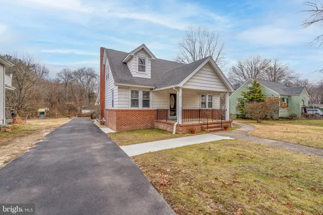 a view of a house with a yard and large tree