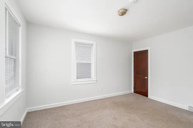 an empty room with windows and closet