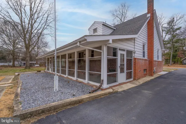 a view of a house with a yard and large tree