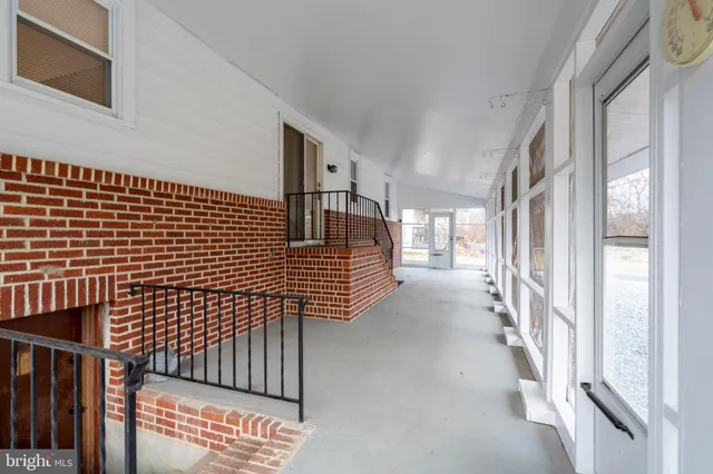 a view of a hallway with wooden floor and windows