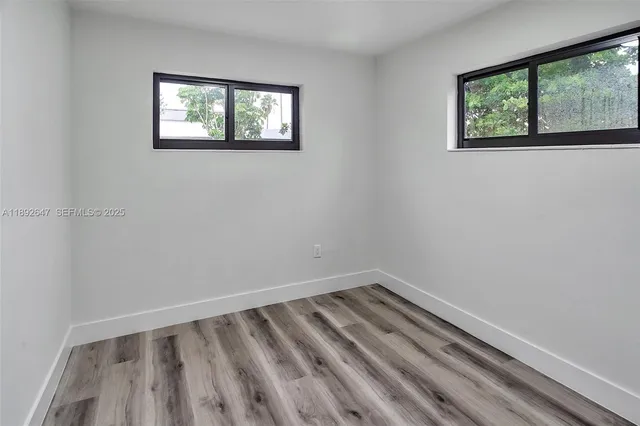 a view of a room with wooden floor and window
