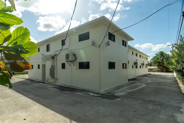 a white building with trees in the background