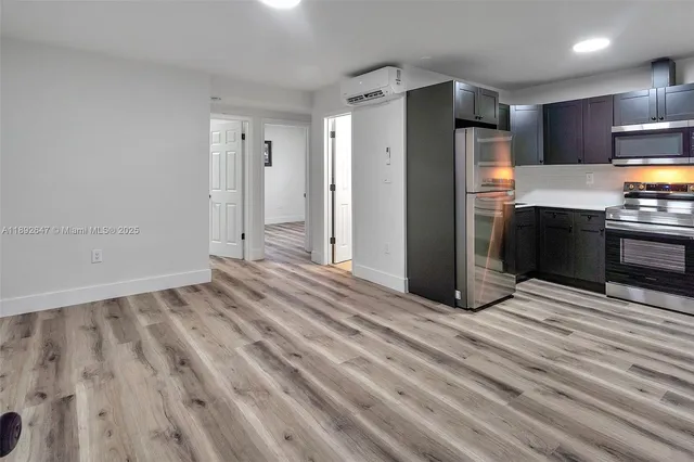 a view of kitchen with refrigerator microwave and stove top oven