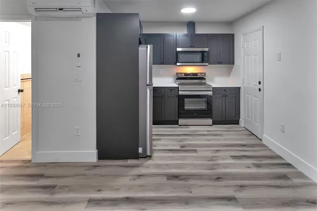 a kitchen with stainless steel appliances kitchen island granite countertop a refrigerator and a stove top oven