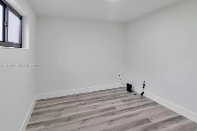 a view of a room with wooden floor and white walls