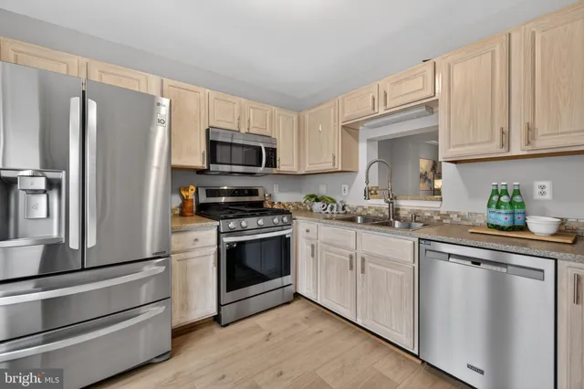 a kitchen with white cabinets stainless steel appliances and a sink