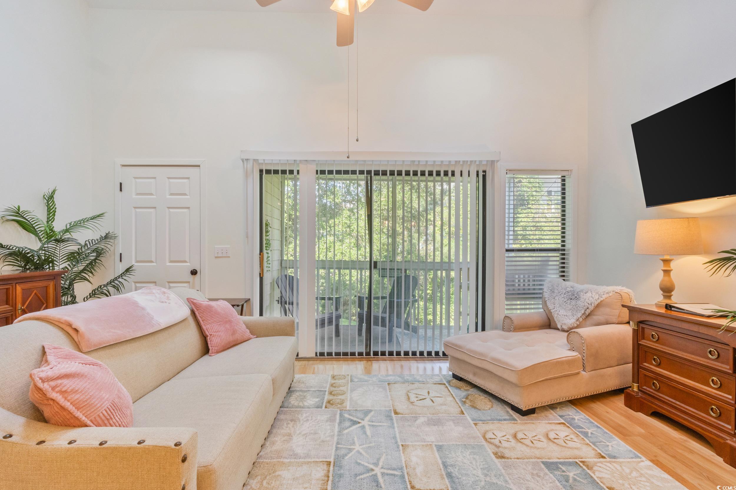 4506 Little River Inn Lane Little River, SC 29566 - Photo 23 of 34 Living room featuring a towering ceiling, wood finished floors, plenty of natural light, and a ceiling fan