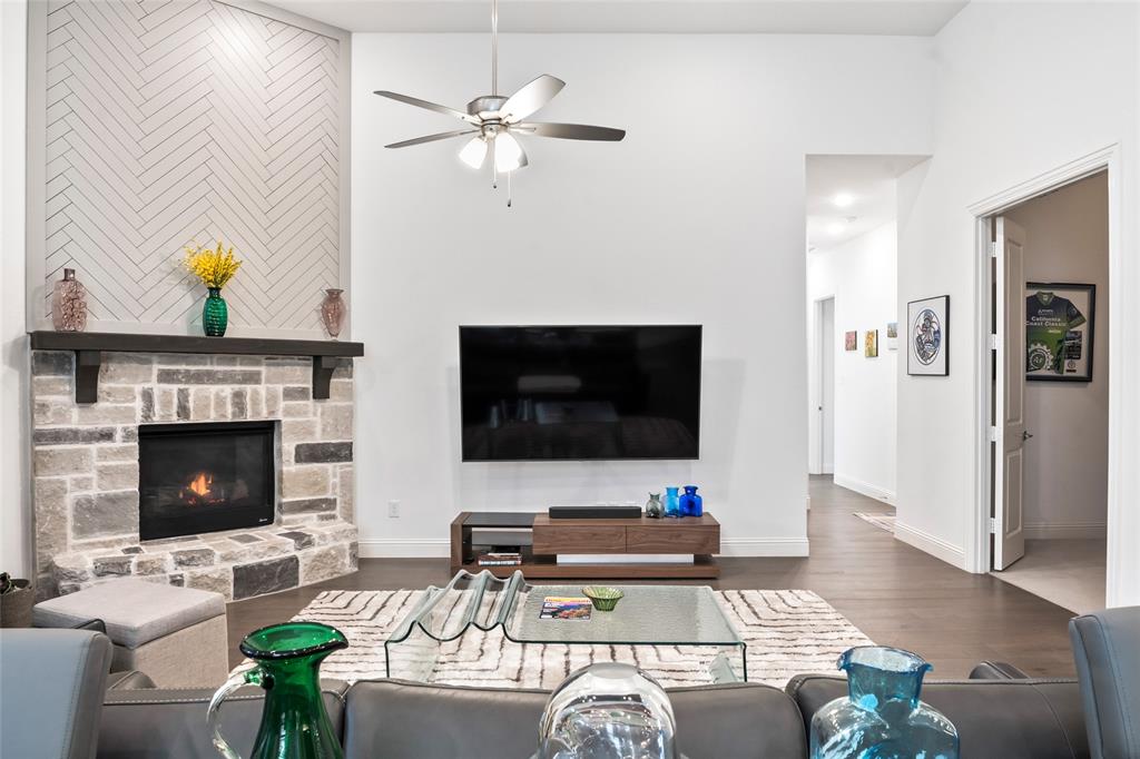 2109 Georgetown Boulevard Prosper, TX 75078 - Photo 13 of 40 a living room with furniture a fireplace and a flat screen tv
