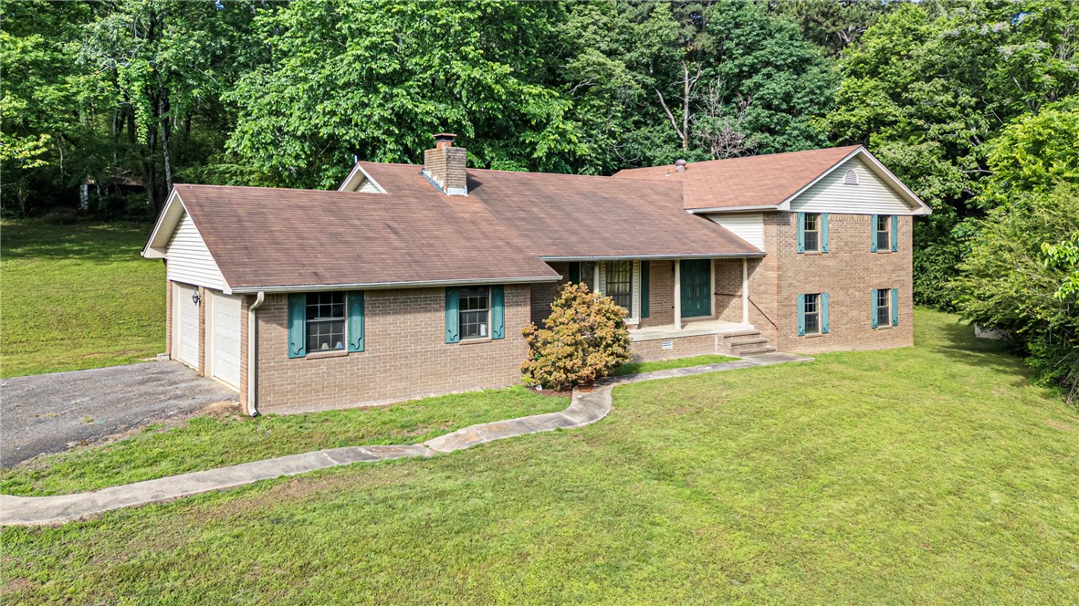 Traditional brick facade home with a two-car garage, front entry porch, and mature landscaping