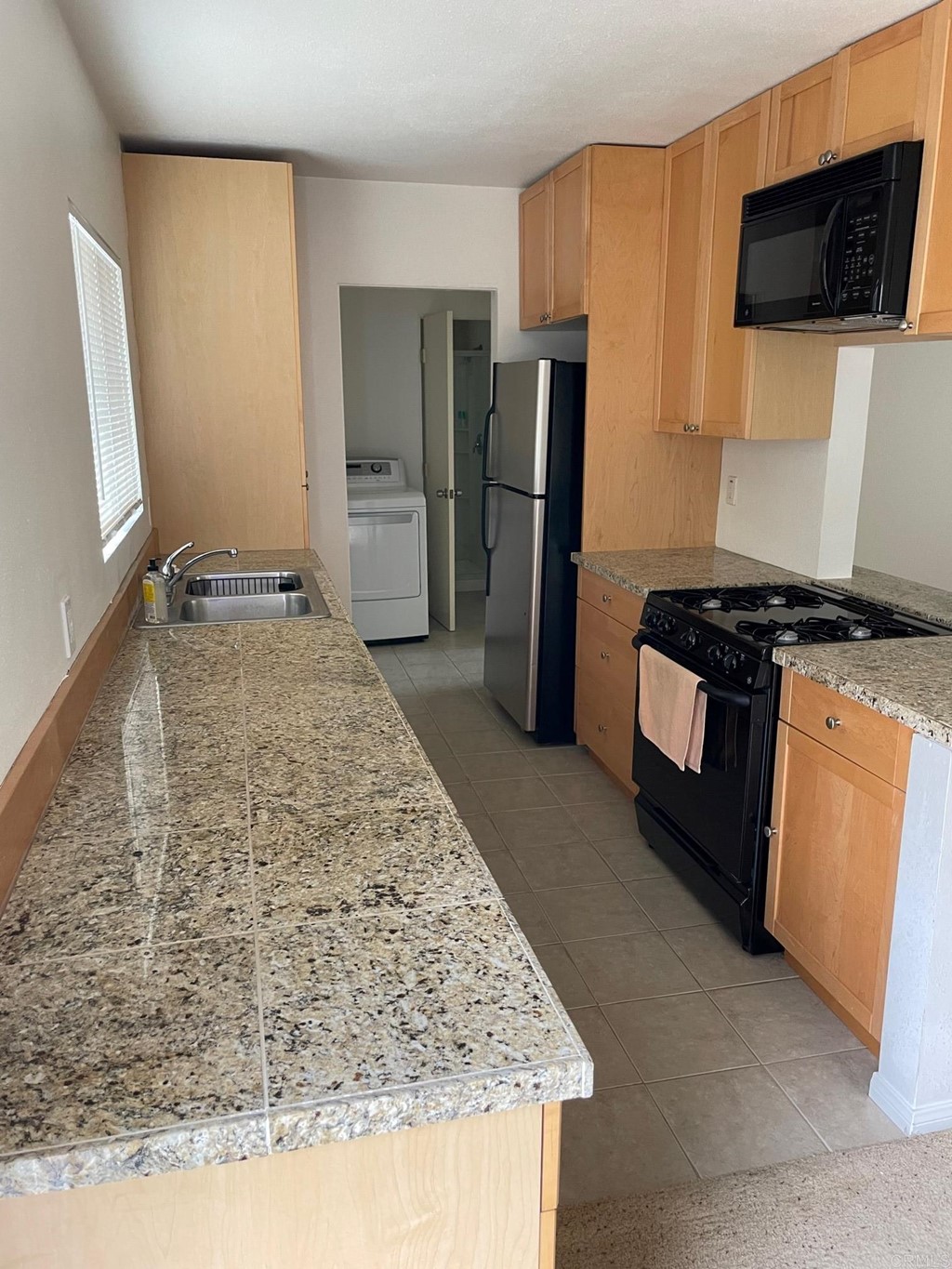 1465 Neptune Avenue Encinitas, CA 92024 - Photo 7 of 13 a kitchen with kitchen island a counter top space cabinets stainless steel appliances and a refrigerator