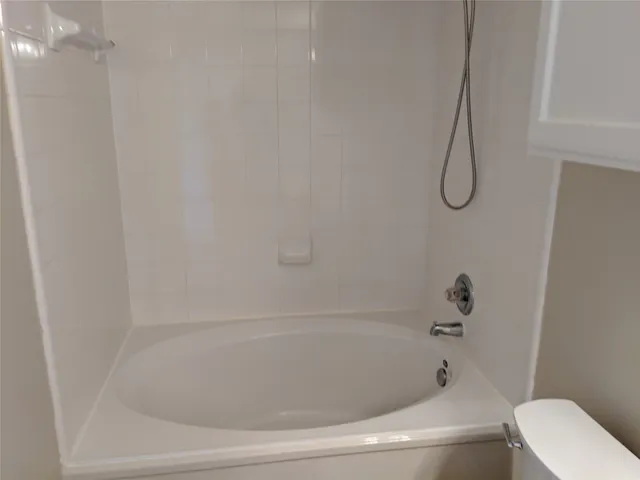 a bathroom with a bath tub with a shower