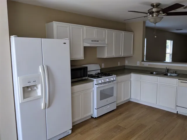 a kitchen with white cabinets and white appliances