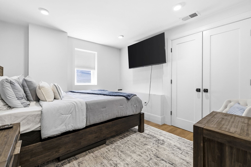 92 Chelsea Street, Unit 1 Boston, MA 02128 - Photo 8 of 14 a bedroom with a bed and a flat screen tv