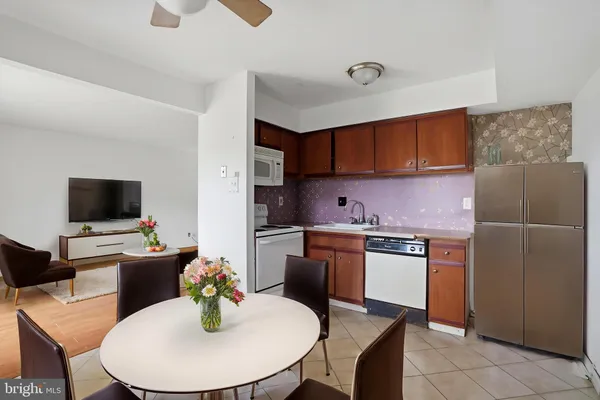 a kitchen with stainless steel appliances kitchen island granite countertop a refrigerator a stove a sink dishwasher with a dining table and chair