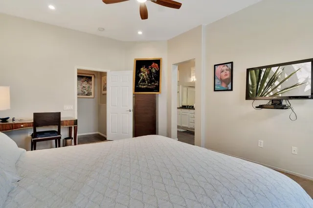 a bedroom with a large bed and a flat screen tv