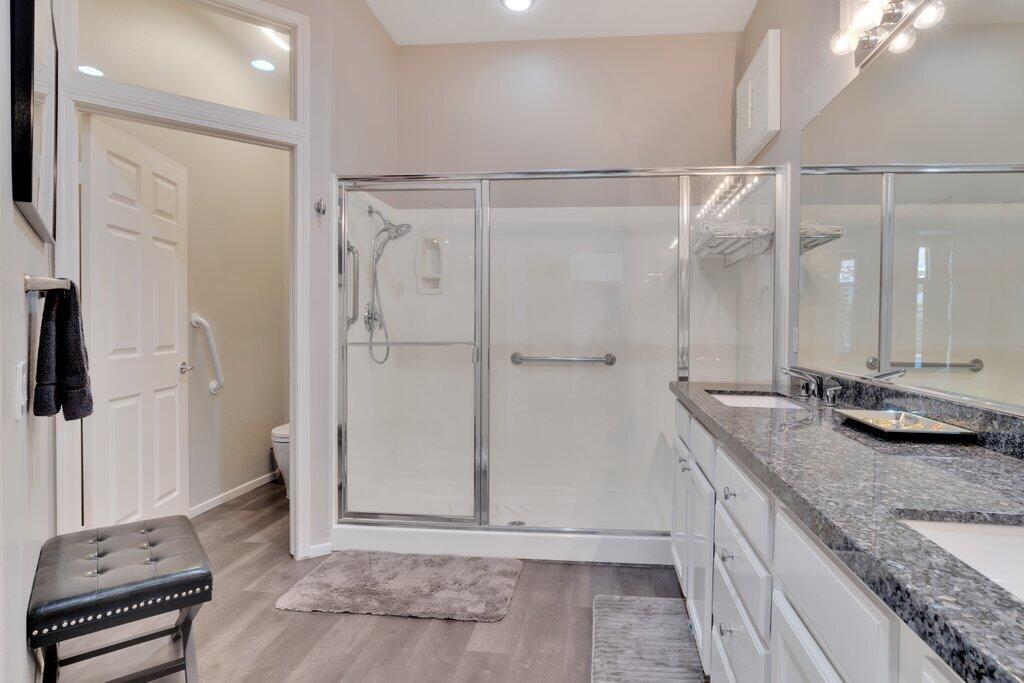 39357 Mirage Circle Palm Desert, CA 92211 - Photo 14 of 32 a bathroom with a granite countertop sink a toilet a mirror and shower