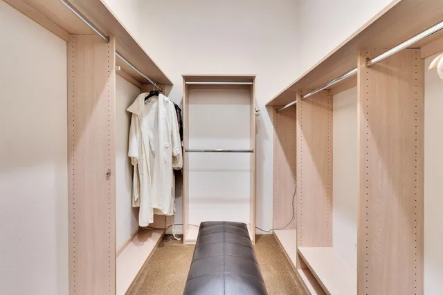 a view of walk in closet with clothes and shoes
