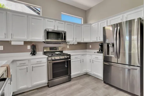 a kitchen with cabinets stainless steel appliances and a window