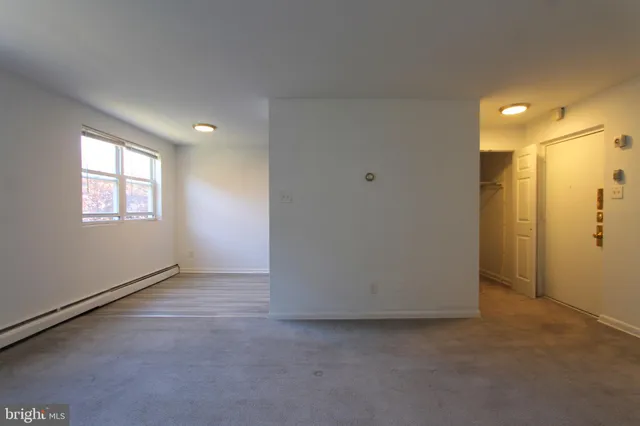 an empty room with windows & closet