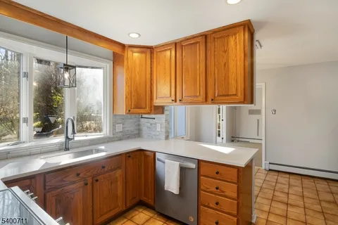 a kitchen with stainless steel appliances a sink cabinets and a large window