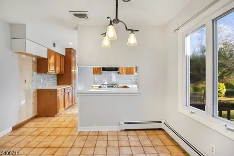 a view of kitchen with stainless steel appliances granite countertop a stove top oven a sink and cabinets