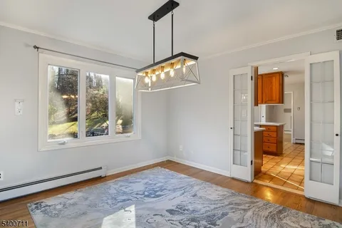 a view of a livingroom with wooden floor and a flat screen tv