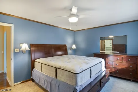 a bedroom with a bed and a flat tv screen on dresser