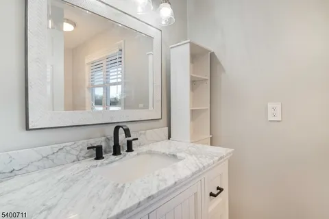 a bathroom with a granite countertop sink and a mirror